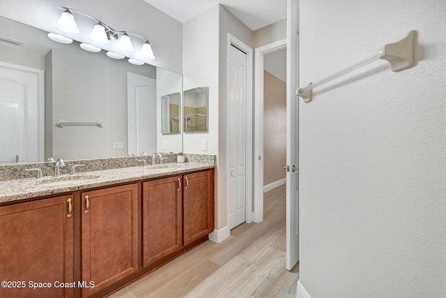 5727 Tamarac Dr, Melbourne, FL 32940 - full bathroom featuring wood finished floors and double vanity
