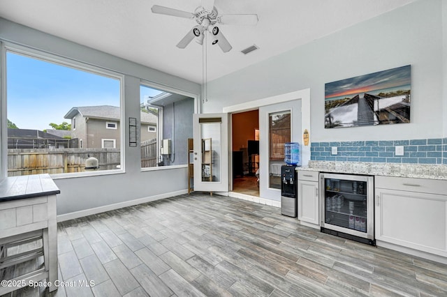 1067 Red Bud Cir, Rockledge, FL 32955 - bar featuring beverage cooler, a ceiling fan, light wood-style floors, and backsplash