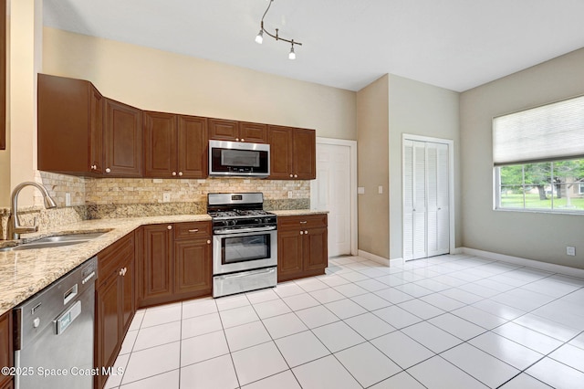 1067 Red Bud Cir, Rockledge, FL 32955 - kitchen featuring appliances with stainless steel finishes, decorative backsplash, light stone countertops, light tile patterned floors, and rail lighting