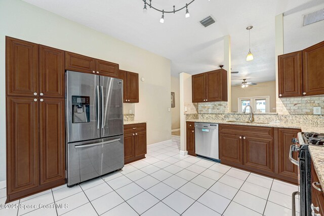 1067 Red Bud Cir, Rockledge, FL 32955 - kitchen featuring appliances with stainless steel finishes, decorative backsplash, a ceiling fan, and light tile patterned floors