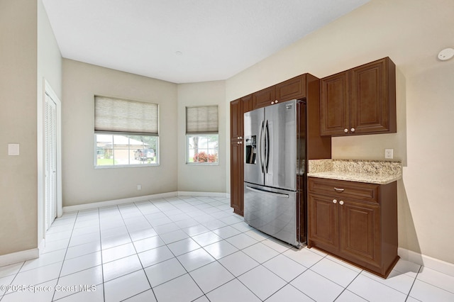 1067 Red Bud Cir, Rockledge, FL 32955 - kitchen with stainless steel refrigerator with ice dispenser, light stone counters, and light tile patterned floors