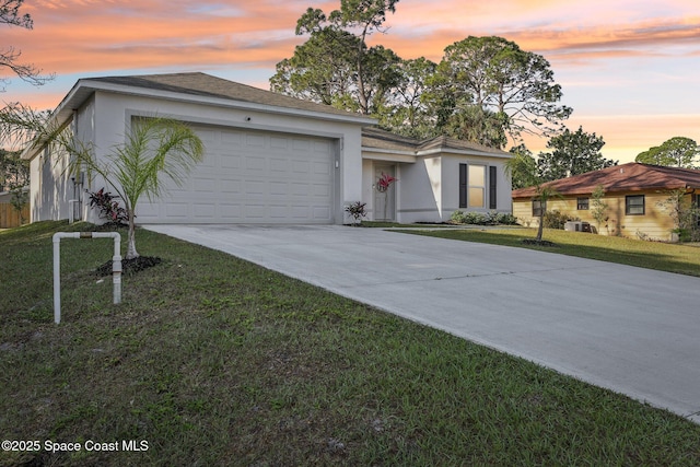 982 Pyracantha St NW, Palm Bay, FL 32907 - ranch-style home featuring stucco siding, concrete driveway, an attached garage, and a front lawn