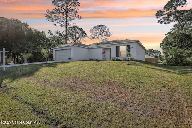 982 Pyracantha St NW, Palm Bay, FL 32907 - view of front of house featuring stucco siding, a front lawn, a garage, and driveway