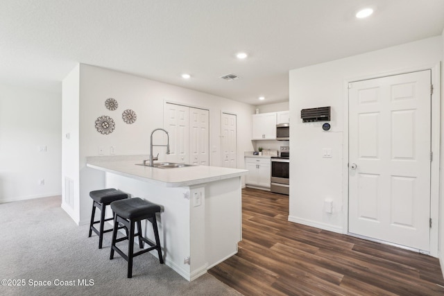 982 Pyracantha St NW, Palm Bay, FL 32907 - kitchen featuring appliances with stainless steel finishes, a kitchen bar, recessed lighting, white cabinets, and light countertops