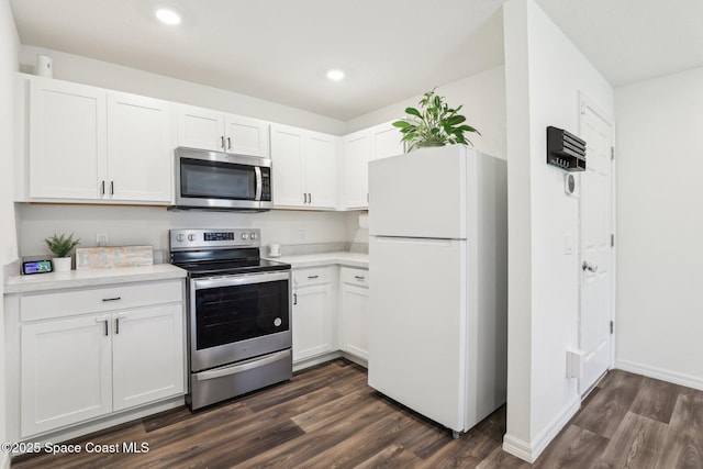 982 Pyracantha St NW, Palm Bay, FL 32907 - kitchen featuring appliances with stainless steel finishes, light countertops, dark wood-style floors, white cabinets, and recessed lighting