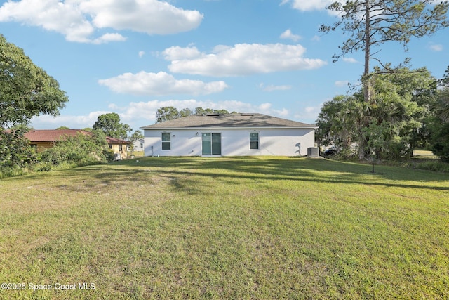 982 Pyracantha St NW, Palm Bay, FL 32907 - back of property with a yard and stucco siding