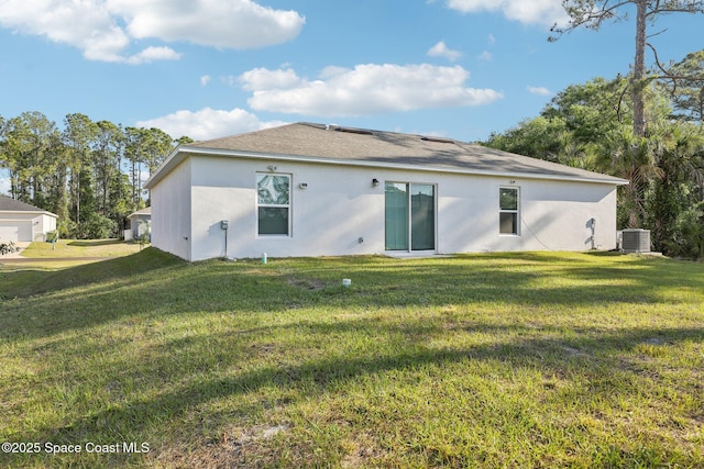 982 Pyracantha St NW, Palm Bay, FL 32907 - back of property featuring a lawn, stucco siding, and a shingled roof