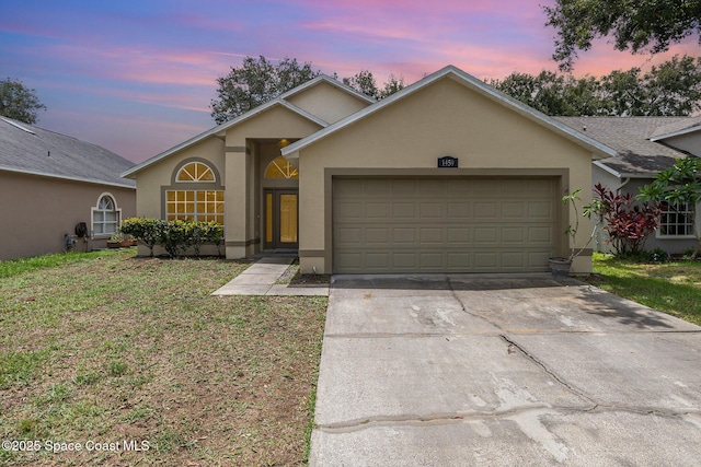 1459 Crane Creek Blvd, Melbourne, FL 32940 - ranch-style house featuring stucco siding, an attached garage, driveway, and a lawn