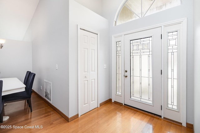 1459 Crane Creek Blvd, Melbourne, FL 32940 - foyer entrance featuring light wood-style floors, high vaulted ceiling, and a chandelier
