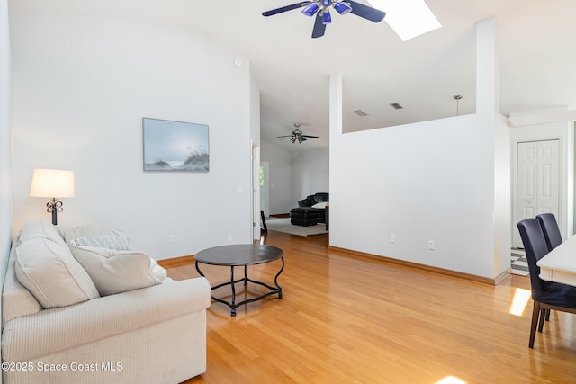 1459 Crane Creek Blvd, Melbourne, FL 32940 - living area featuring a ceiling fan, vaulted ceiling, light wood-style floors, and a skylight