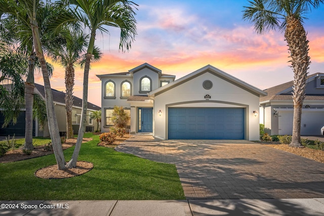 8522 Strom Park Dr, Melbourne, FL 32940 - view of front of property featuring decorative driveway, a garage, stucco siding, and a lawn