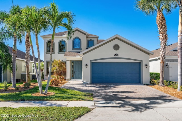 8522 Strom Park Dr, Melbourne, FL 32940 - mediterranean / spanish-style home with stucco siding, driveway, and an attached garage