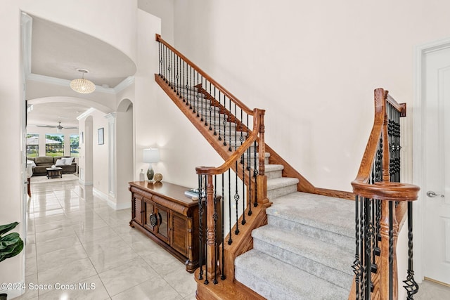 8522 Strom Park Dr, Melbourne, FL 32940 - stairway featuring arched walkways, ornamental molding, marble finish flooring, decorative columns, and ceiling fan