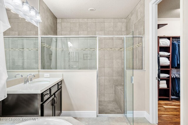 8522 Strom Park Dr, Melbourne, FL 32940 - full bath featuring a walk in closet, vanity, a shower stall, a textured ceiling, and wood finished floors