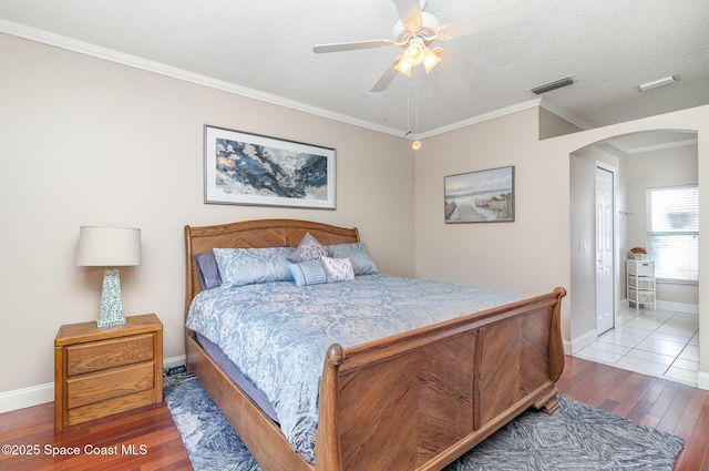 1510 Gardenton St NW, Palm Bay, FL 32907 - bedroom with wood finished floors, arched walkways, a textured ceiling, ornamental molding, and a ceiling fan