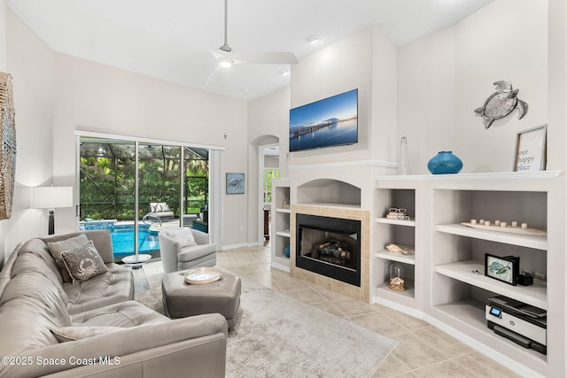 172 Whaler Dr, Melbourne Beach, FL 32951 - tiled living room with ceiling fan, built in features, arched walkways, and a tiled fireplace