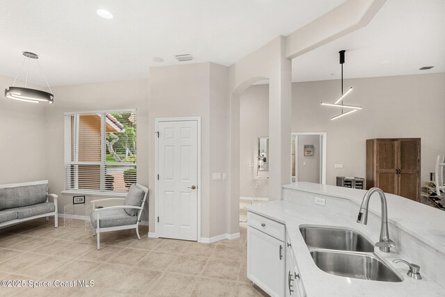 172 Whaler Dr, Melbourne Beach, FL 32951 - kitchen featuring white cabinets, hanging light fixtures, arched walkways, and light tile patterned flooring