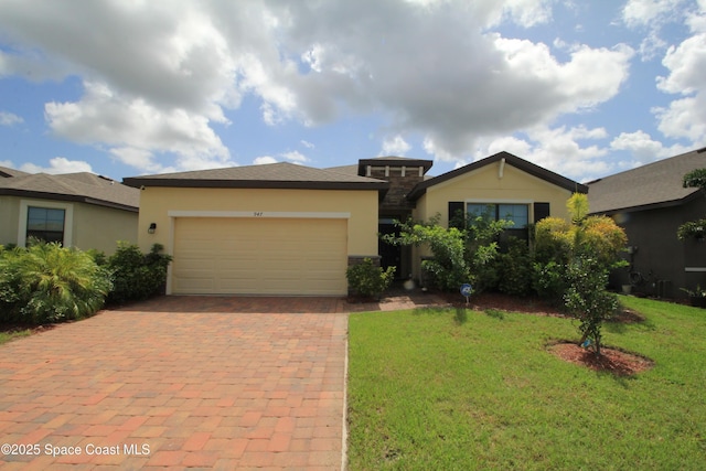 947 Remington Green Dr SE, Palm Bay, FL 32909 - view of front of house featuring stucco siding, decorative driveway, a garage, and a front lawn