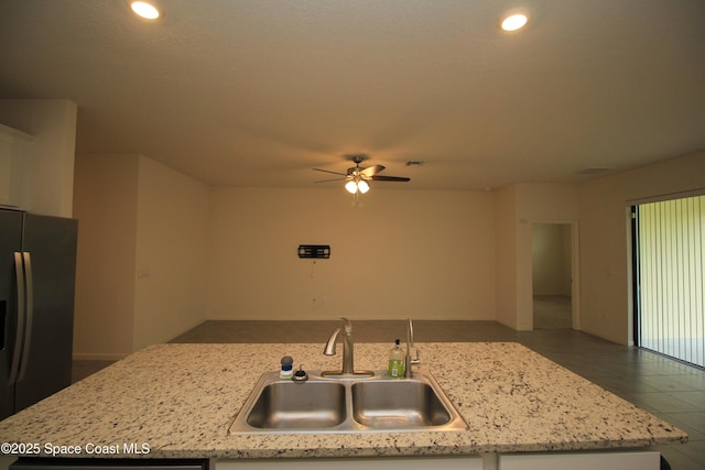 947 Remington Green Dr SE, Palm Bay, FL 32909 - kitchen with fridge with ice dispenser, a ceiling fan, light stone counters, open floor plan, and recessed lighting
