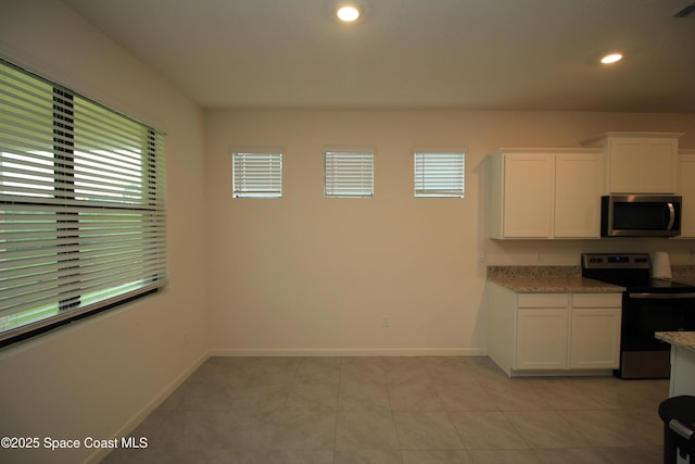 947 Remington Green Dr SE, Palm Bay, FL 32909 - kitchen featuring stainless steel appliances, white cabinets, recessed lighting, light stone counters, and light tile patterned floors