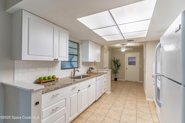 1768 Hudson Cir S, Melbourne, FL 32935 - kitchen with white appliances, backsplash, white cabinetry, light tile patterned flooring, and a ceiling fan