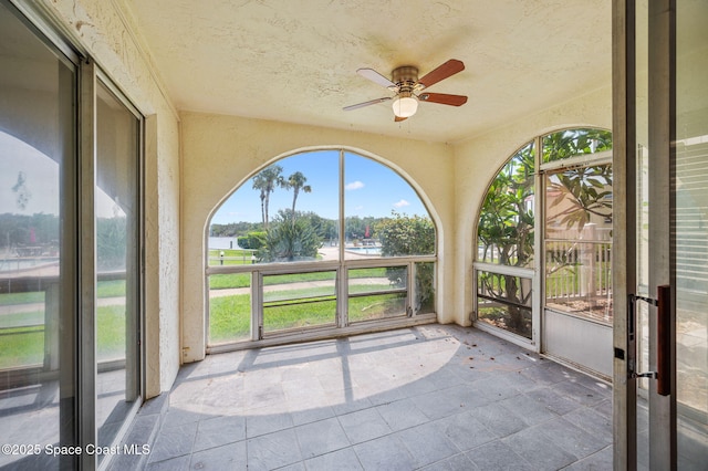 1727 Minutemen Cswy Unit 108, Cocoa Beach, FL 32931 - unfurnished sunroom featuring ceiling fan, healthy amount of natural light, a water view, and a textured ceiling