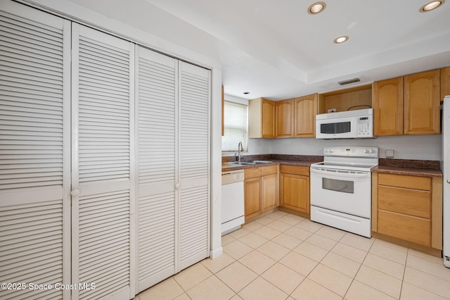 1727 Minutemen Cswy Unit 108, Cocoa Beach, FL 32931 - kitchen featuring white appliances, dark countertops, recessed lighting, light tile patterned floors, and a tray ceiling