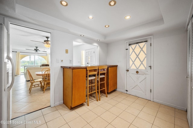 1727 Minutemen Cswy Unit 108, Cocoa Beach, FL 32931 - kitchen with a tray ceiling, recessed lighting, a ceiling fan, white fridge with ice dispenser, and light tile patterned flooring