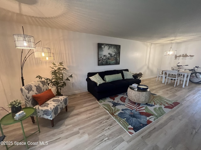 3799 S Banana River Blvd Unit 104, Cocoa Beach, FL 32931 - living room featuring wood finished floors and a chandelier