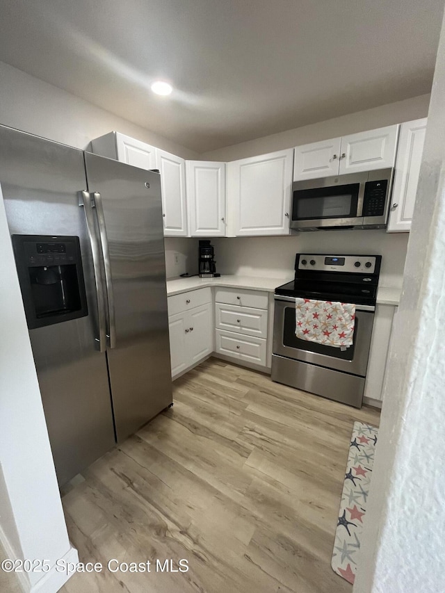 3799 S Banana River Blvd Unit 104, Cocoa Beach, FL 32931 - kitchen featuring stainless steel appliances, light wood-type flooring, white cabinetry, light countertops, and recessed lighting