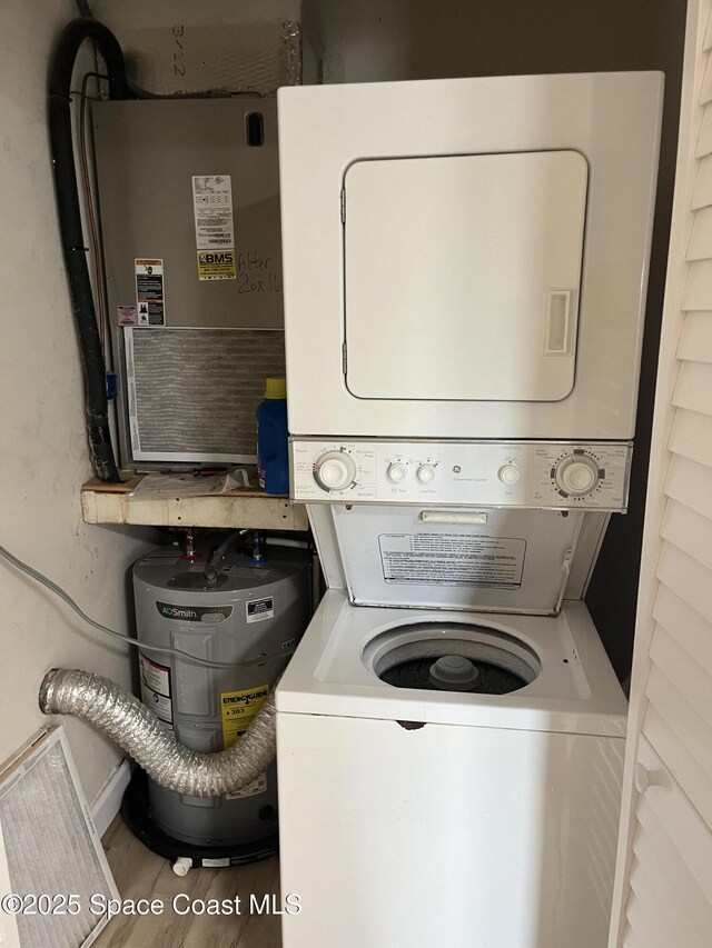3799 S Banana River Blvd Unit 104, Cocoa Beach, FL 32931 - laundry room featuring stacked washer / dryer, water heater, and wood finished floors