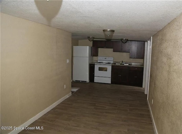 1038 W 10th St, Lakeland, FL 33805 - kitchen featuring white appliances, dark wood-style flooring, a textured ceiling, a textured wall, and light countertops