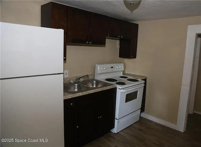 1038 W 10th St, Lakeland, FL 33805 - kitchen with white appliances, dark wood-style flooring, a textured ceiling, light countertops, and dark brown cabinets