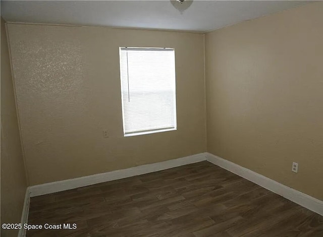 1038 W 10th St, Lakeland, FL 33805 - empty room with dark wood-type flooring and baseboards