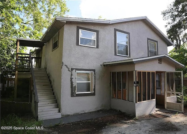 1038 W 10th St, Lakeland, FL 33805 - view of property exterior featuring a sunroom, stucco siding, and stairway