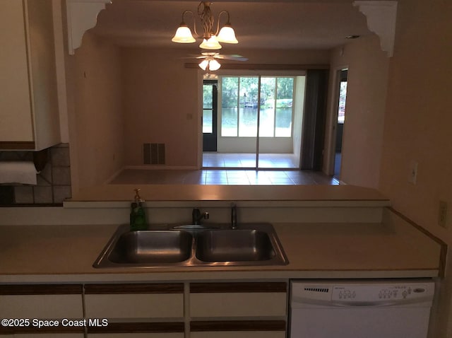 33 Kings Colony Ct, Palm Coast, FL 32137 - kitchen with dishwasher, ceiling fan, light countertops, white cabinets, and hanging light fixtures