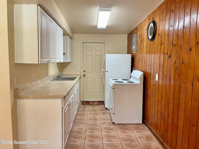 316 Bay Ave, Cocoa, FL 32922 - kitchen with electric range, wooden walls, light countertops, white cabinets, and light tile patterned floors
