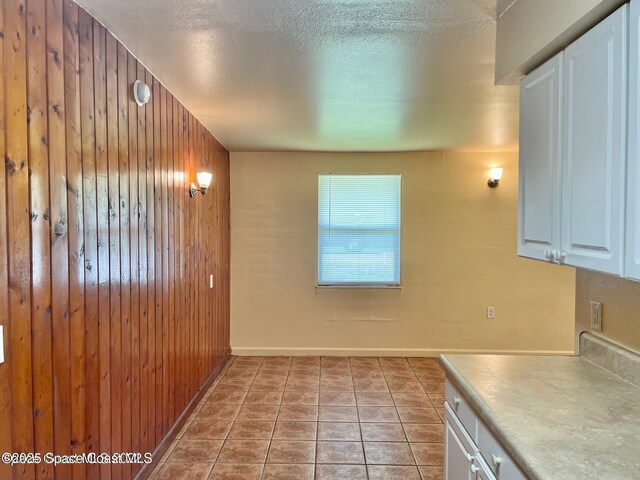 316 Bay Ave, Cocoa, FL 32922 - kitchen with wood walls, white cabinets, a textured ceiling, and light countertops