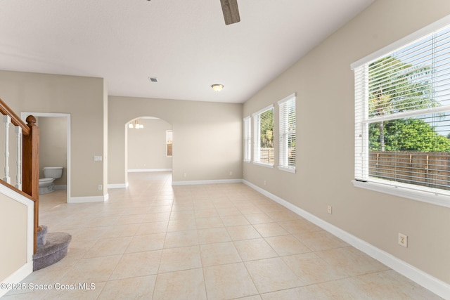 2032 Elkins Pt, Melbourne, FL 32935 - unfurnished room featuring arched walkways, light tile patterned floors, a ceiling fan, and stairway
