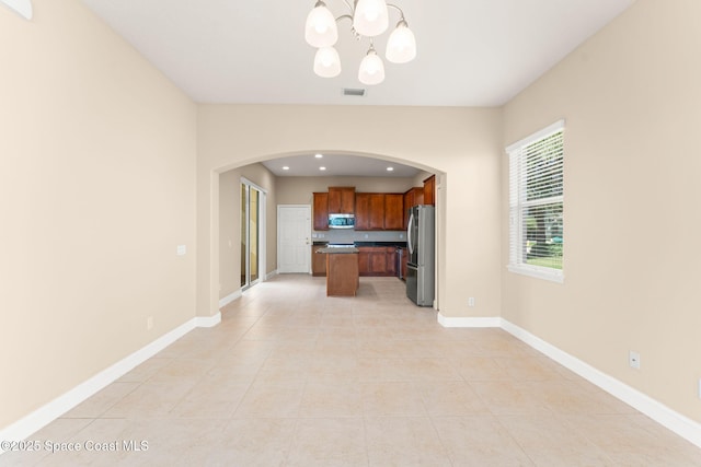 2032 Elkins Pt, Melbourne, FL 32935 - kitchen with appliances with stainless steel finishes, arched walkways, a chandelier, open floor plan, and light tile patterned flooring
