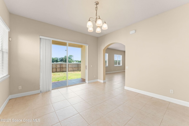 2032 Elkins Pt, Melbourne, FL 32935 - empty room featuring arched walkways, a chandelier, and light tile patterned floors