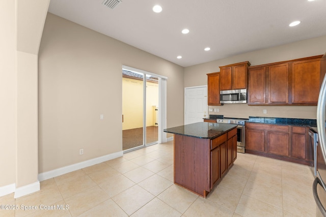 2032 Elkins Pt, Melbourne, FL 32935 - kitchen with stainless steel appliances, recessed lighting, a center island, dark stone countertops, and light tile patterned floors