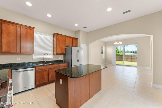 2032 Elkins Pt, Melbourne, FL 32935 - kitchen with stainless steel dishwasher, freestanding refrigerator, arched walkways, light tile patterned flooring, and dark stone countertops