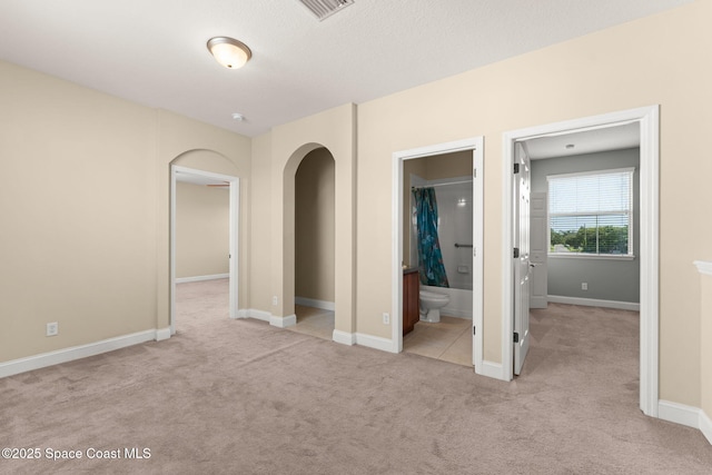 2032 Elkins Pt, Melbourne, FL 32935 - unfurnished bedroom with carpet, arched walkways, and ensuite bathroom