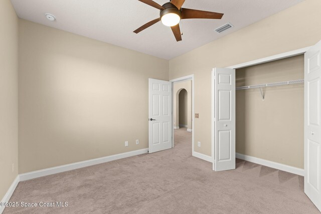 2032 Elkins Pt, Melbourne, FL 32935 - unfurnished bedroom featuring carpet, arched walkways, a closet, and a ceiling fan