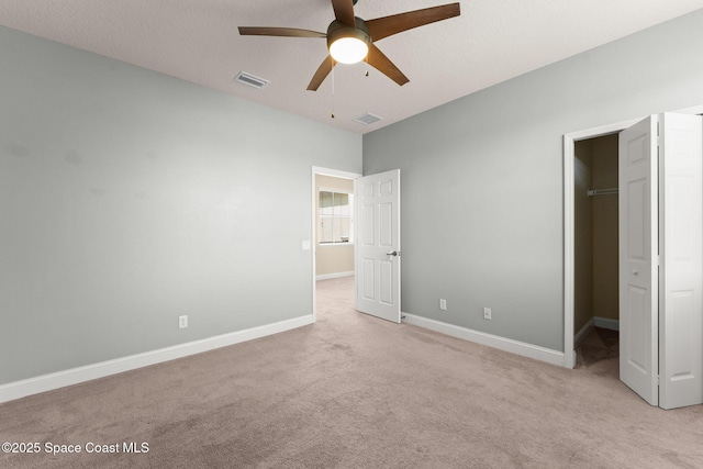 2032 Elkins Pt, Melbourne, FL 32935 - unfurnished bedroom featuring a spacious closet, light colored carpet, a closet, and ceiling fan