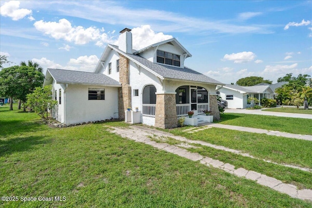 415 2nd Ave, Indialantic, FL 32903 - view of front of property featuring a chimney, covered porch, a front yard, stone siding, and stucco siding