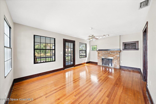 415 2nd Ave, Indialantic, FL 32903 - unfurnished living room featuring a stone fireplace, wood finished floors, and ceiling fan