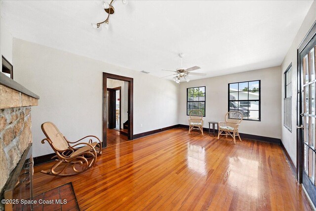 415 2nd Ave, Indialantic, FL 32903 - sitting room with hardwood / wood-style floors, a stone fireplace, and a ceiling fan