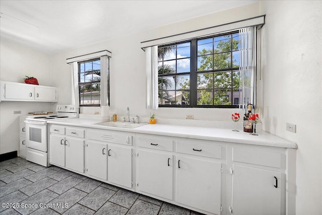 415 2nd Ave, Indialantic, FL 32903 - kitchen featuring electric range, white cabinets, and light countertops